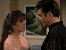 a man and a woman are looking at each other .