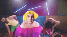 a man with a yellow wig is surrounded by other men
