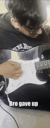 a young man playing an electric guitar with the words bro gave up behind him