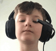 a young boy wearing a pair of headphones with a microphone attached to it .