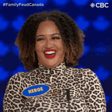 a woman wearing a leopard print shirt has a name tag that says heroe