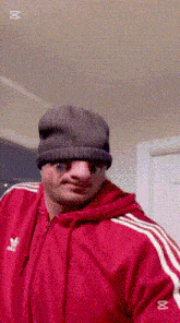 a man wearing a beanie and an adidas jacket