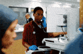 a nurse is talking on a cell phone while standing in front of a dell computer .