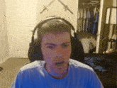 a man wearing headphones is sitting in front of a closet with swords on the wall