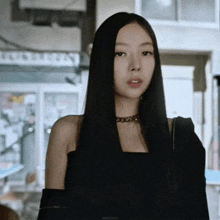 a woman with long black hair is standing in front of a building with a sign that says burberry