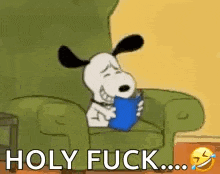 snoopy is sitting in a chair reading a book and holding a cup .
