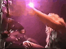 a purple light is shining on a person 's hand
