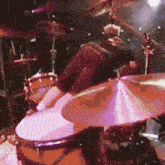 a man is playing a drum set with a purple cymbal