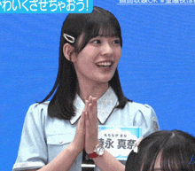 a girl wearing a watch and a name tag that says ' aoi ' on it