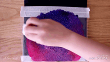 a person 's hand is holding a purple and pink sponge on a piece of paper that says chloe art