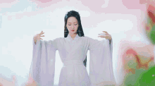 a woman in a white dress with her arms outstretched