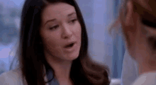 a close up of two women talking to each other in a room .