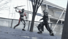 a man in a superhero costume is fighting another man with a sword in front of a building with chinese writing on it