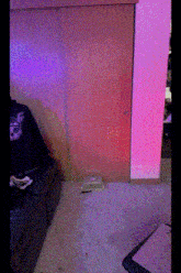 a person playing a video game in a room with pink lights