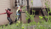 two superheros are fighting each other in front of a building