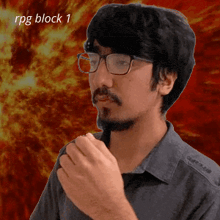 a man with glasses and a beard is standing in front of a fire background with the words rpg block 1 on the bottom