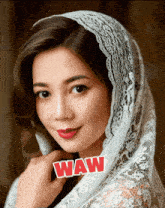 a woman wearing a white lace head scarf with the word waw written on it