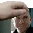 a hand is holding a man 's head in front of a white background .