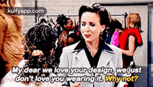 a woman in a suit is talking to another woman in front of a group of people .