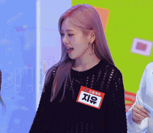 a woman with pink hair has a name tag that says " 지유 " on it