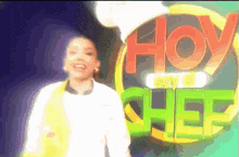 a woman in a chef 's uniform is standing in front of a sign that says hoy soy chef