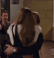 a man is holding a woman in his arms while they are hugging each other .