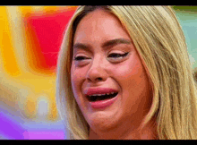 a close up of a woman 's face with tears coming out of her eyes