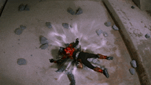 a superhero is laying on the ground with a purple light coming out of his chest