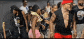 a group of people are dancing in a room with a guitar in the background .