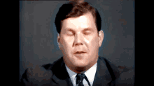 a man in a suit and tie is making a funny face