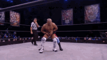 a wrestler in a wrestling ring with a referee behind him