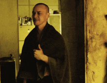 a man is wrapped in a blanket and giving a thumbs up sign