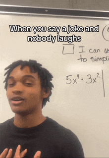 a young man stands in front of a white board with a math problem on it