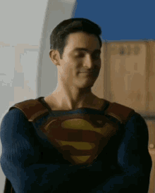 a man in a superman costume with his arms crossed .
