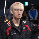 a man wearing glasses and a redbull jacket