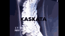 a person is holding a stack of money in front of a sign that says kaskata