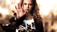 a woman wearing a t-shirt that says " me " holds her hand up
