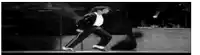 it is a black and white photo of a man dancing on a stage .