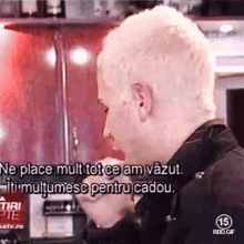 a man with white hair is talking in a foreign language with the number 15 on the bottom
