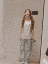 a woman standing in front of a mirror holding a cellphone