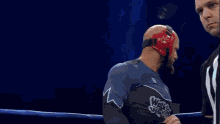 a wrestler is taking off his shirt while wearing a red white and blue outfit