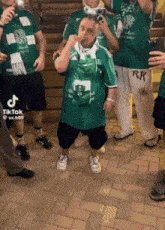 a group of men wearing green shirts with rk written on the bottom