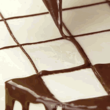 a close up of chocolate being poured on a cake with the words mr.cakes visible