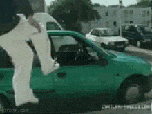 a green car with a gifbin.com watermark on the bottom
