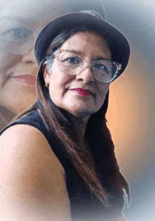 a woman wearing glasses and a hat has a reflection of herself in the background