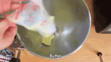 a person is pouring butter into a mixer bowl