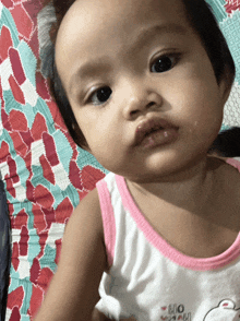 a baby wearing a pink and white tank top that says mom on it