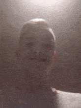 a close up of a man 's face with a glass in front of him