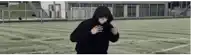 a man in a hoodie is running on a soccer field .