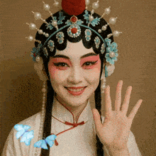 a woman wearing a headdress with pearls and flowers on it waves her hand